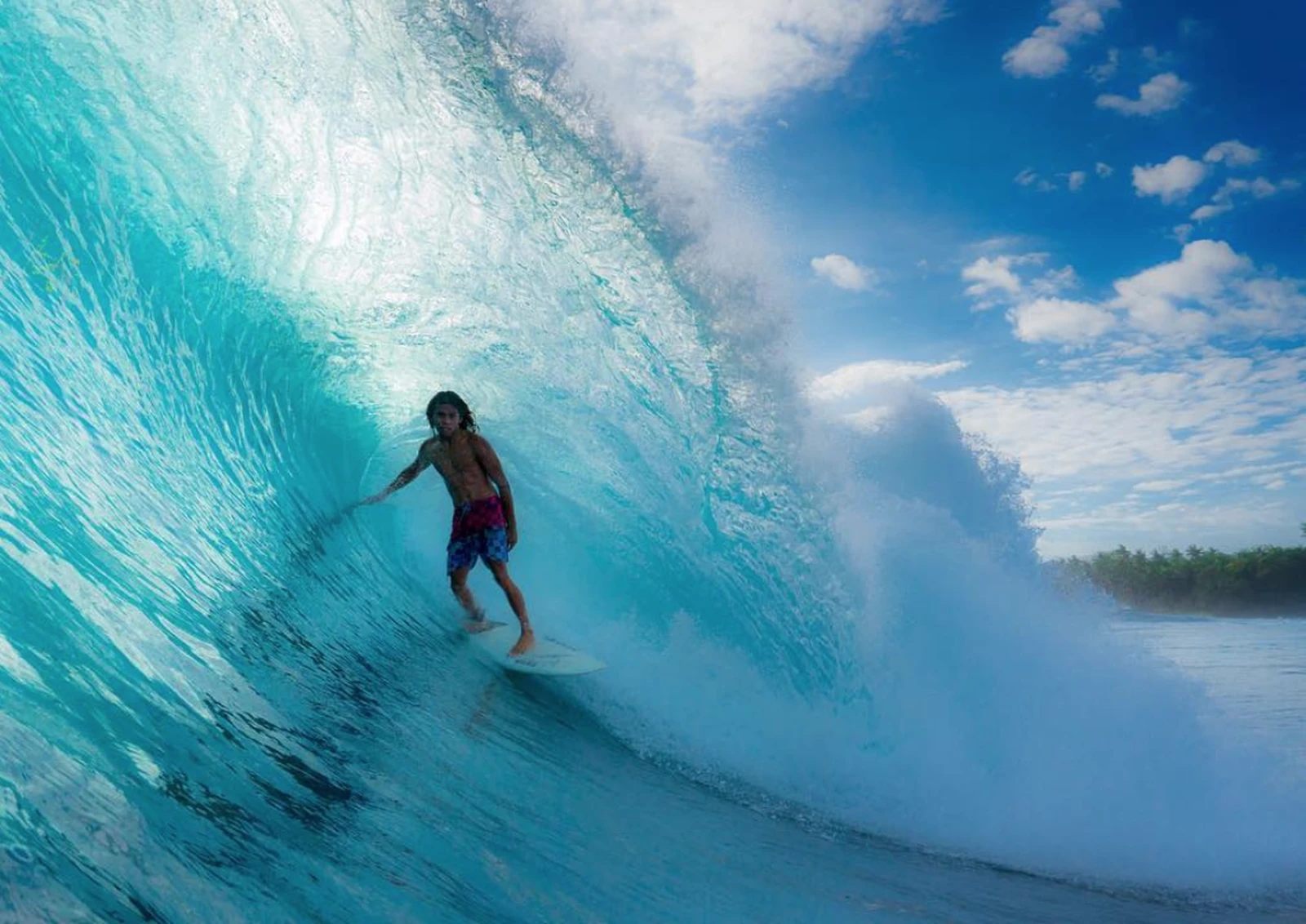 Surfer riding a clean wave on the reef near Cloud 9, Siargao Island