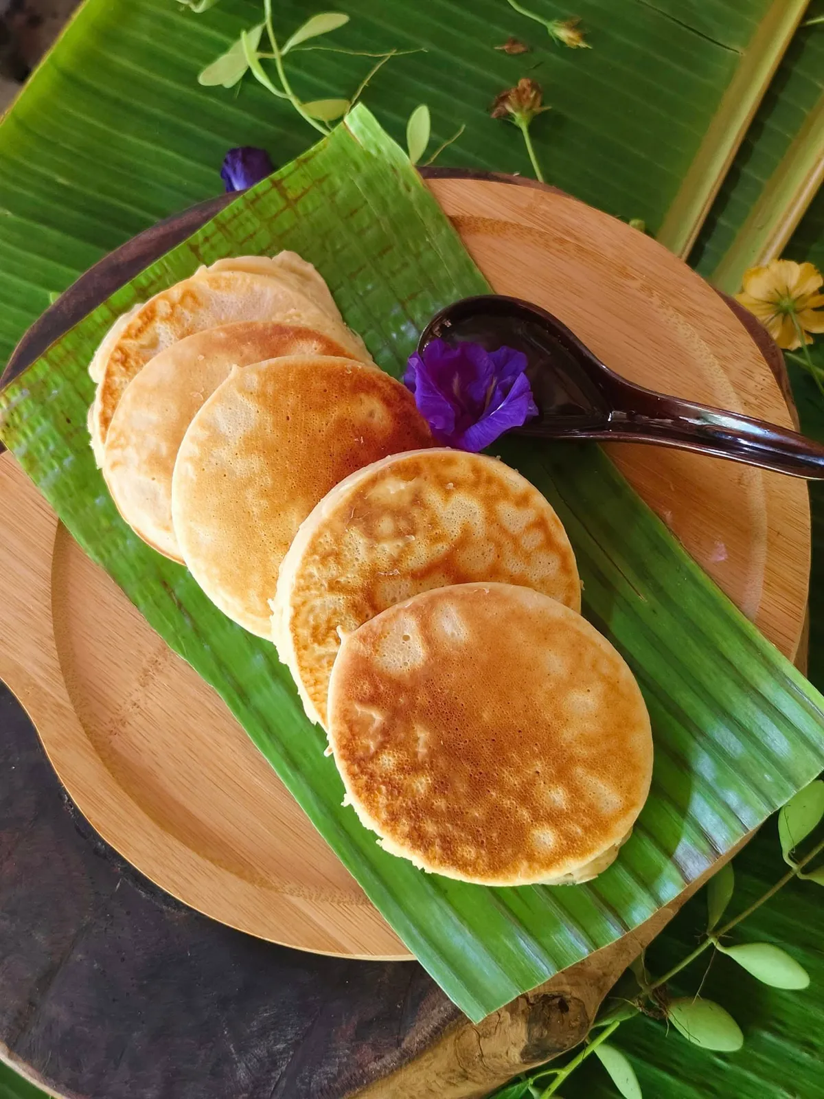 Homemade pancakes served on a banana leaf with a butterfly pea flower at Patrick's beachfront restaurant, Siargao