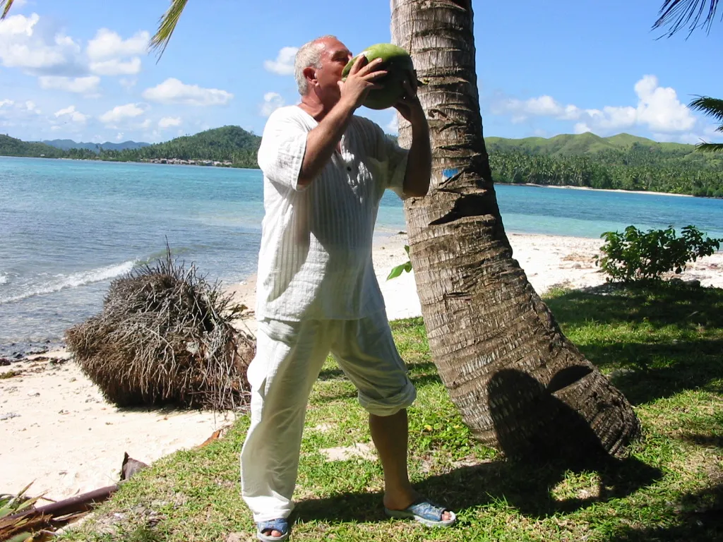 Drinking from a fresh coconut on the quiet General Luna shoreline in the resort's early years