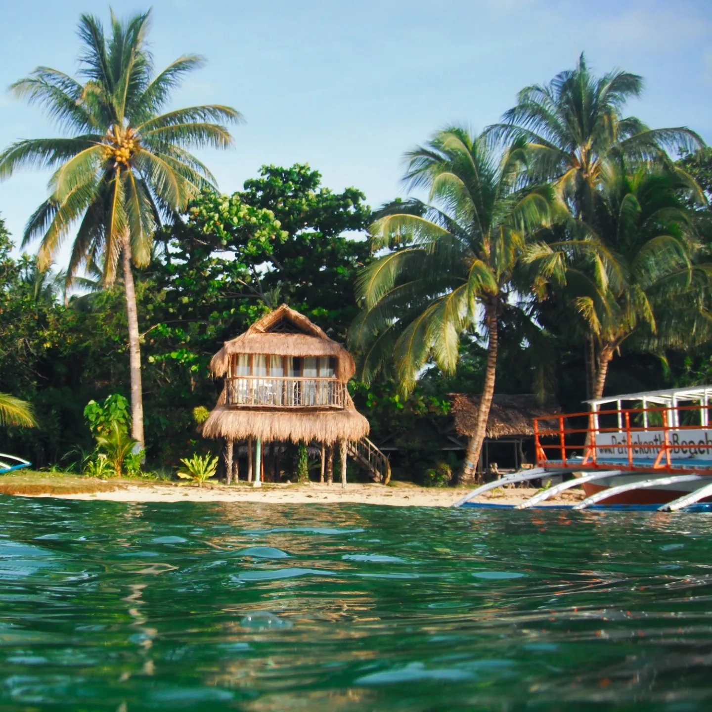 Beachfront cottages of Patrick's on the Beach under palm trees, General Luna, Siargao Island